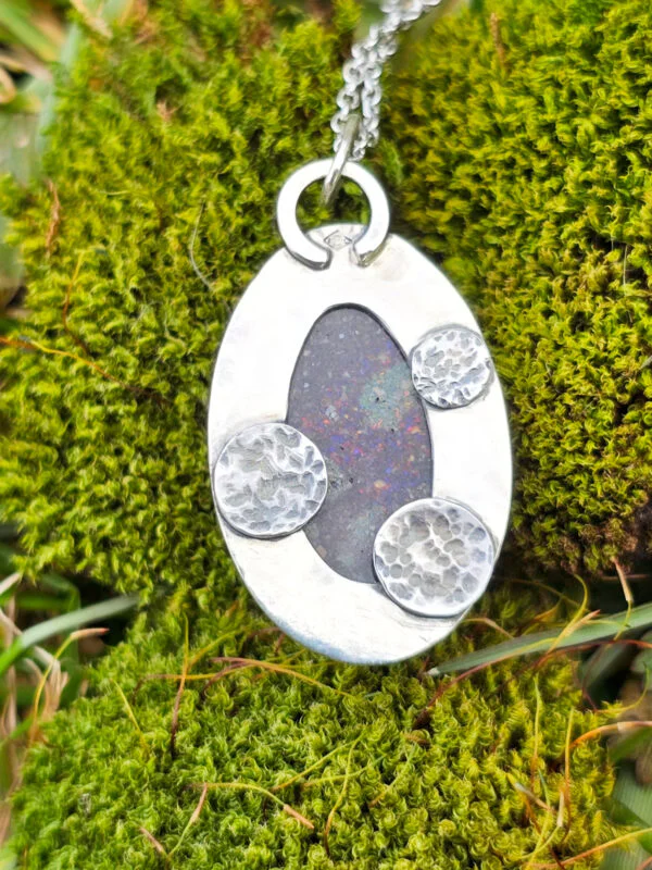 Arrière d'un collier en argent serti d'une Opale noire du Honduras avec des motifs de planètes